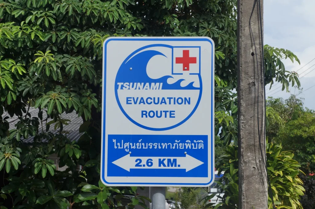 Tsunami evacuation route sign in Mai Khao, Phuket, pointing to a safe area 2.6 km away