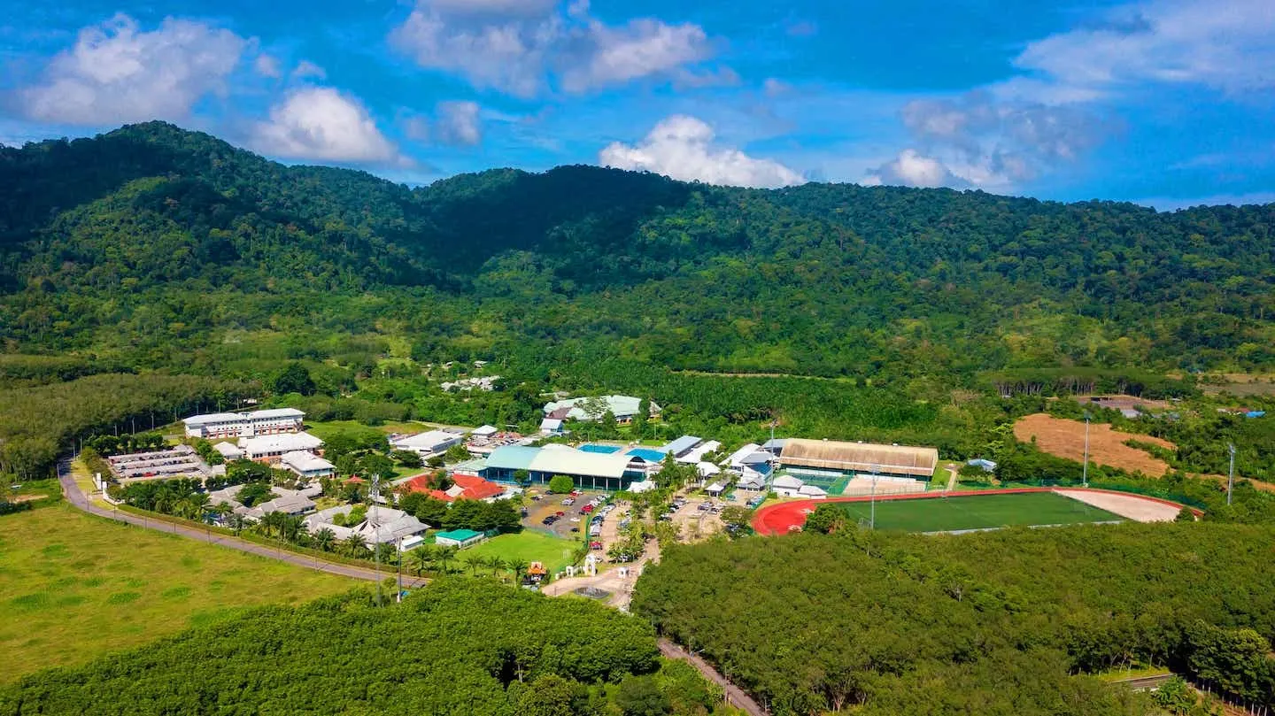 Aerial view of the UWC Thailand International School campus in Thalang, Phuket, below forested hills